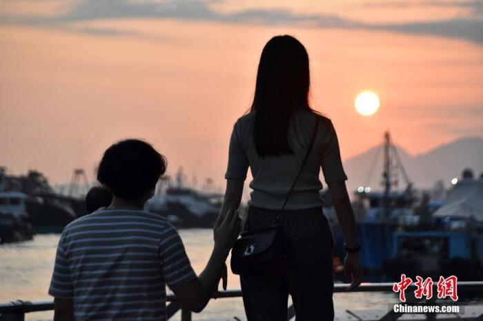 一对情侣在香港仔海滨欣赏日落美景。<a target='_blank' href='/'>中新社</a>记者 洪帆 摄