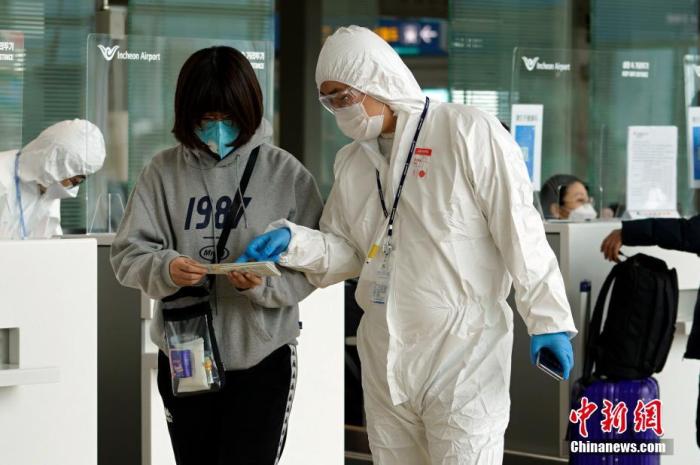 资料图：在韩国仁川机场，航空公司工作人员检查旅客防疫证明等。中新社记者 曾鼐 摄