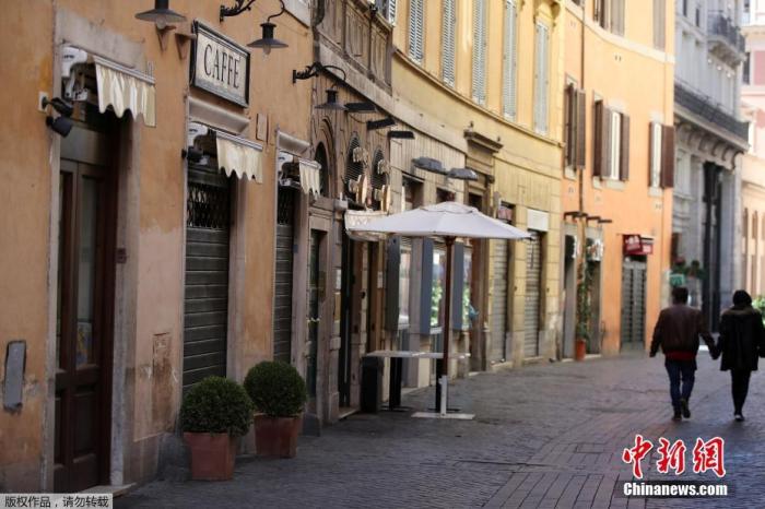 资料图：意大利罗马，人们走过关闭的酒吧和餐馆。