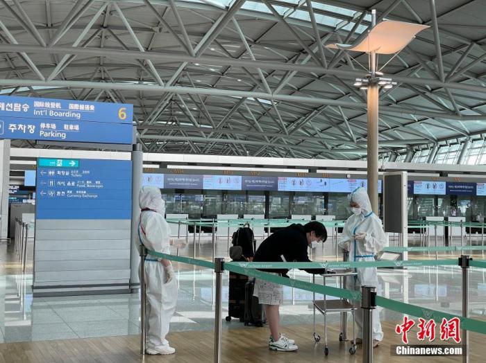 资料图：韩国仁川国际机场工作人员严格执行防疫措施。中新社记者 刘旭 摄