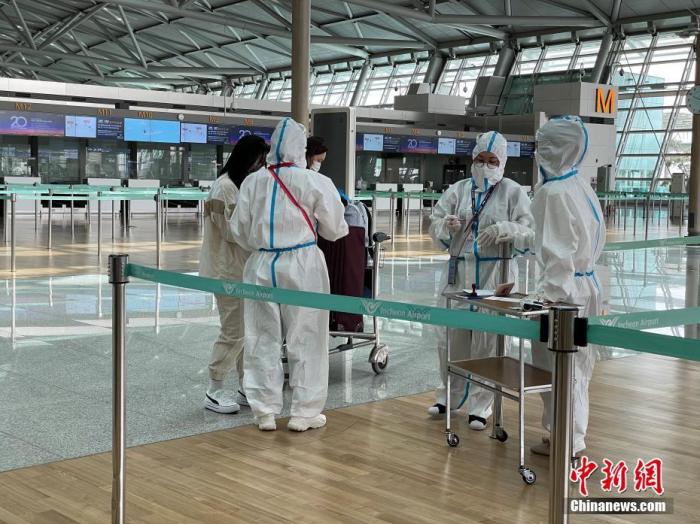 5月7日，韩国仁川国际机场工作人员严格执行防疫措施。中新社记者 刘旭 摄