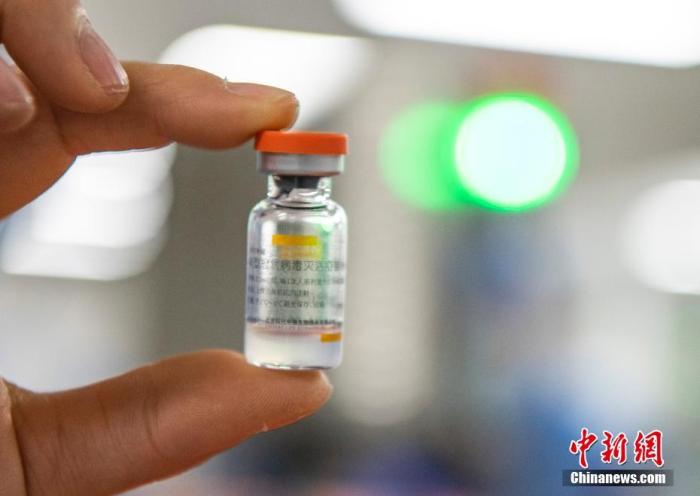 图为2021年1月6日，位于北京市大兴区的北京科兴中维生物技术有限公司的仓库内，工作人员展示一支西林瓶装新冠灭活疫苗。（资料图片）中新社记者 侯宇 摄
