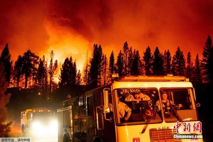 当地时间7月8日，美国加州，贝克沃斯综合火灾一部分的“糖火”在普卢马斯国家森林蔓延，火光映红天空。图为消防抵达现场。