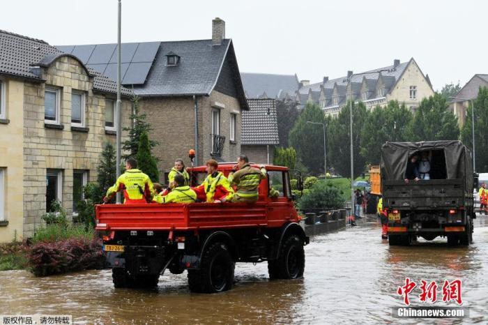当地时间7月15日，在荷兰法肯堡发生大雨后，救生员乘坐救援车辆路过被洪水冲刷的道路。