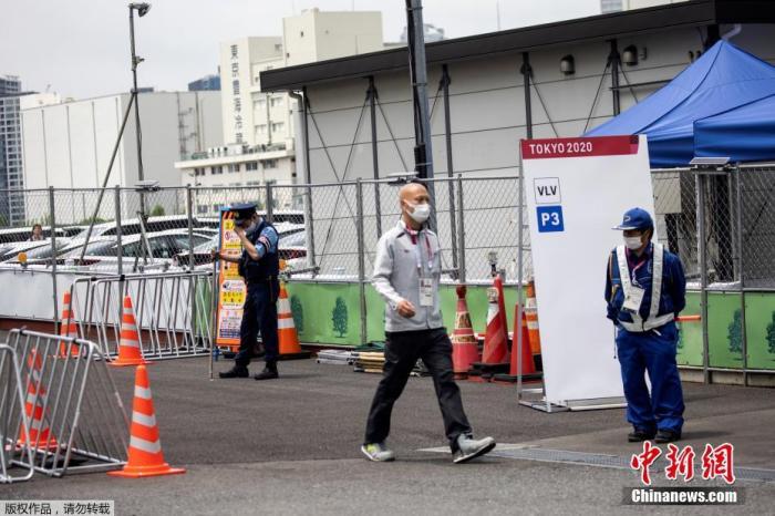 图为东京奥运会的一名参赛者通过安保人员走出东京奥运村和残奥会村。
