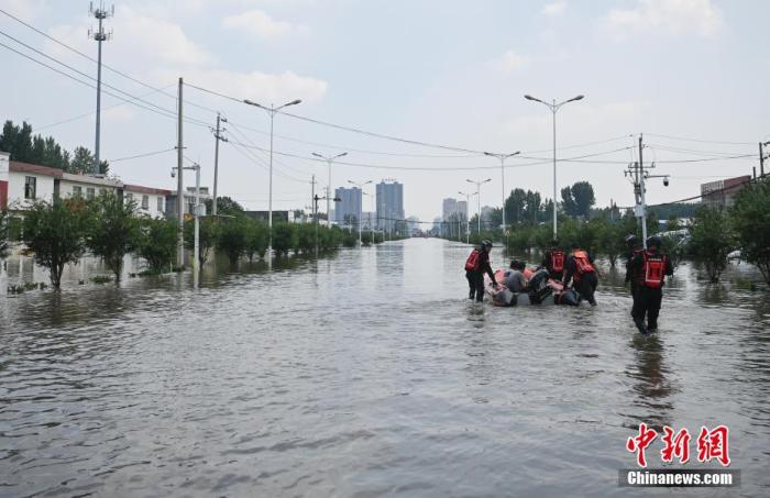 2021年7月25日，河南新乡，多支救援力量在当地受灾较为严重的小朱庄开展救援工作。资料图为救援人员在小朱庄转移民众。 中新社记者 崔楠 摄