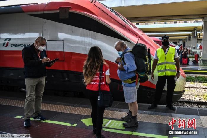 资料图：意大利都灵，意大利铁路工作人员在车站检查乘客的绿色通行证。