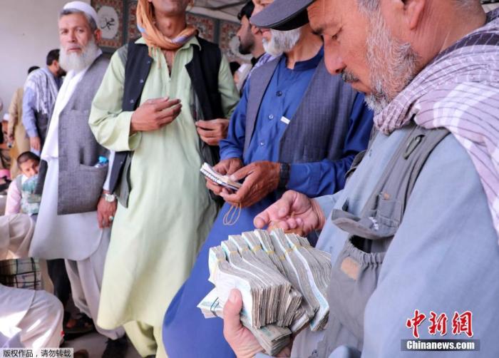 当地时间9月4日，阿富汗喀布尔，在阿富汗塔利班接管后，银行和市场重新开放。图为人们在货币市场兑换钞票。