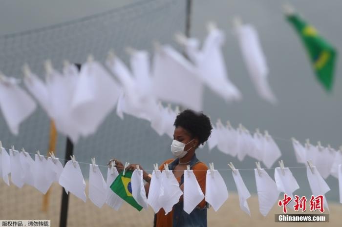 当地时间10月8日，巴西里约一民间组织为纪念死于新冠肺炎的60万巴西人，在科帕卡帕纳海竖起桅杆，并在上面悬挂600条白色手帕，活动组织者称这600条白手帕除了纪念病亡的60万同胞。