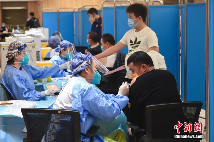 资料图：10月26日，医护人员为北京新发地市场员工接种新冠疫苗加强针。 中新社记者 田雨昊 摄