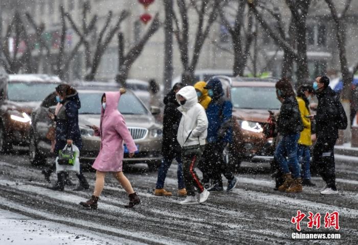 资料图：市民在降雪天气出行。中新社记者 刘新 摄