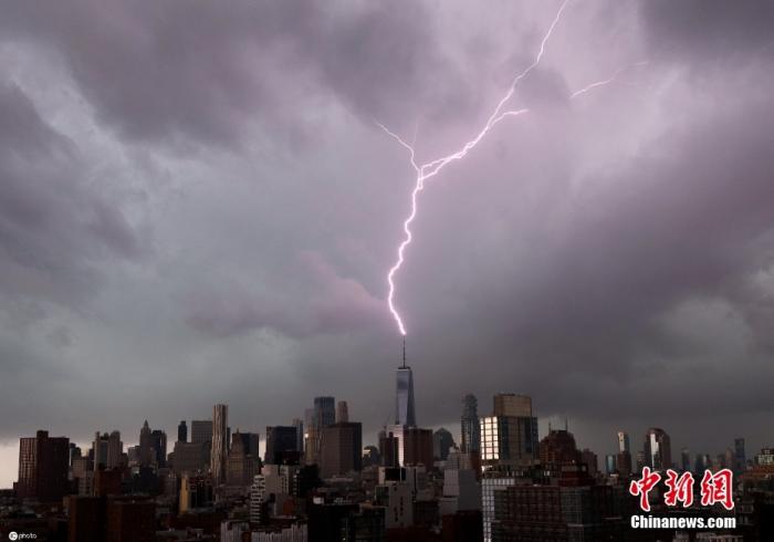 资料图：当地时间2021年11月13日，美国纽约，暴风雨来临前，乌云掠过曼哈顿的高楼，一道闪电击中了世贸中心一号大楼的塔尖。图片来源：ICphoto