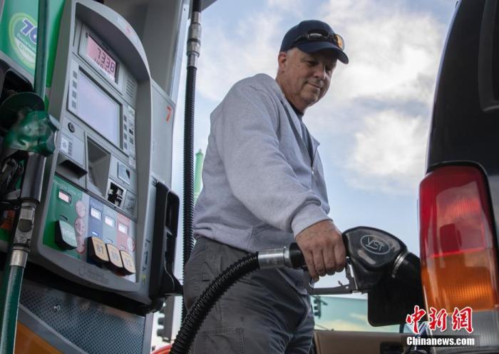 资料图：一位车主在美国加州圣马刁县一处加油站内加油。 中新社记者 刘关关 摄