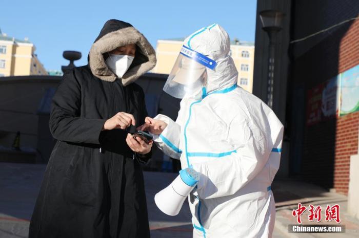 资料图：12月2日，内蒙古满洲里市，工作人员帮助市民打开防疫信息。中新社发 王化勇 摄