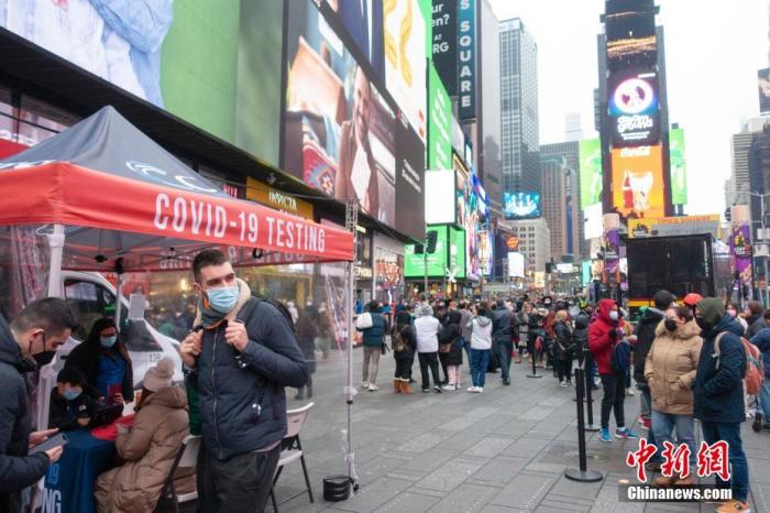 当地时间12月29日，美国纽约，民众在时报广场的一处新冠病毒检测点排队检测。中新社记者 王帆 摄