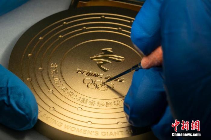 近日，2022年北京冬奥会和冬残奥会奖牌在上海完成验收。据上海造币有限公司介绍，一枚奖牌需要经过18道生产工艺和20道质量检验。其中最重要的难点在金牌的传统金工压亮手艺的使用上，一枚金牌压亮需要研磨师傅在显微镜下工作8小时才能完成。上海造币公司 供图