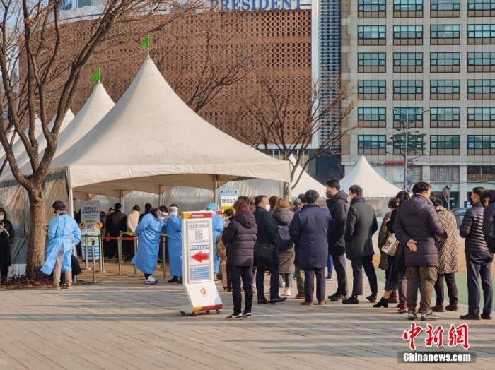 当地时间1月26日，在位于韩国首尔市厅门前的检测点外，民众排队进行核酸检测。当日，韩国中央防疫对策本部通报，截至当日0时，韩国较前一天0时新增新冠肺炎确诊病例13012例。 中新社记者 刘旭 摄
