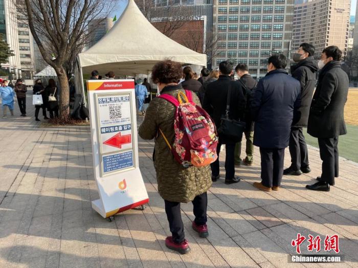 当地时间1月26日，在位于韩国首尔市厅门前的检测点外，民众排队进行核酸检测。当日，韩国中央防疫对策本部通报，截至当日0时，韩国较前一天0时新增新冠肺炎确诊病例13012例。 中新社记者 刘旭 摄