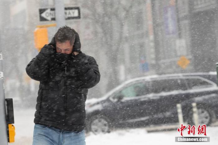 当地时间1月29日，一场冬季风暴袭击美国东北部，纽约迎来这个冬天规模最大的一场降雪。图为皇后区一位路人捂脸前行。 中新社记者 廖攀 摄