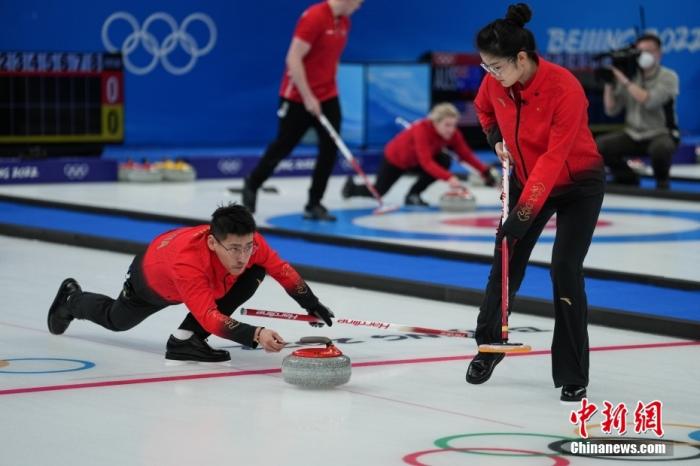 2月2日晚，北京冬奥会冰壶混双循环赛在北京国家游泳中心“冰立方”开赛，中国队7:6战胜瑞士队，迎来开门红。图为中国冰壶队凌智(左)、范苏圆(右)在比赛中。 中新社记者 崔楠 摄