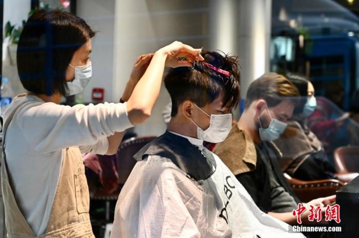 2月8日下午，香港特区政府宣布收紧防疫措施安排，当中理发店或发型屋被纳入表列处所，并须于10日起关闭至本月24日。图为香港市民于发型屋剪头发。 中新社记者 李志华 摄