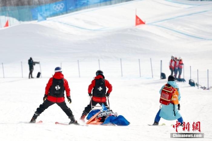 2月9日，北京2022年冬奥会单板滑雪女子障碍追逐比赛在张家口云顶滑雪公园举行。图为一名运动员受伤后被带离场地。 中新社记者 富田 摄