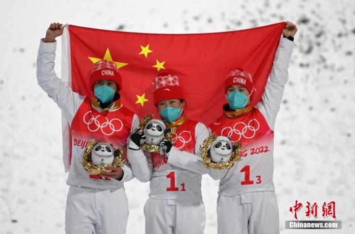 2月10日晚，北京2022年冬奥会自由式滑雪空中技巧混合团体决赛在张家口云顶滑雪公园进行，中国队夺得亚军。图为中国队选手贾宗洋(左)、徐梦桃(中)和齐广璞(右)在比赛后庆祝。 中新社记者 翟羽佳 摄