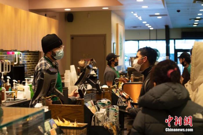 当地时间2月10日，美国纽约市皇后区一家咖啡店人们戴口罩消费。 中新社记者 廖攀 摄