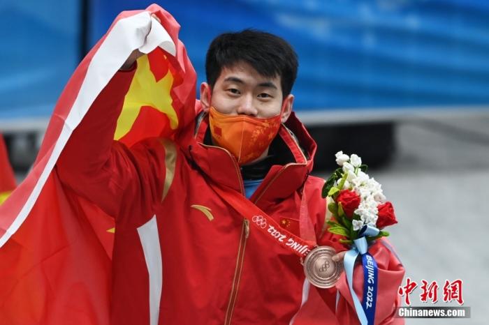 2月11日，北京冬奥会男子钢架雪车比赛结束争夺，中国选手闫文港以四轮4分01秒77的成绩摘得铜牌，创造了中国选手在这一项目的历史最好成绩。图为中国选手闫文港身披国旗。 中新社记者 何蓬磊 摄