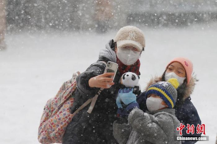 2月13日，北京迎来农历虎年首场降雪，北京动物园内的游客在雪中合影。 中新社记者 韩海丹 摄