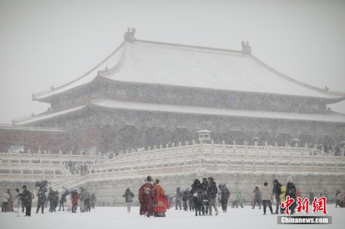 2月13日，北京迎来农历壬寅虎年首场降雪，民众在雪中游览故宫。 中新社记者 盛佳鹏 摄