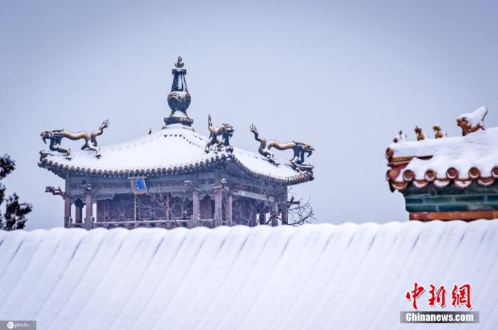 2月13日，一场春雪降临北京，银装素裹的故宫，更有一番别样的风韵。游客们纷纷打卡，领略红墙碧瓦迎春雪的故宫雪景。图片来源：ICphoto