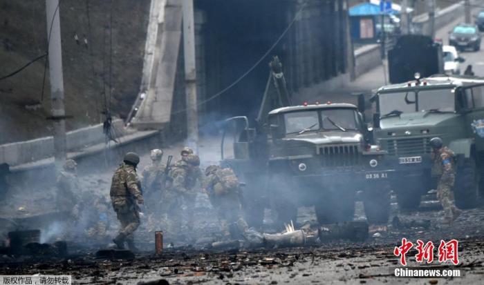 当地时间2月26日，据在场的乌克兰军人称，乌克兰军队在乌克兰首都基辅与俄罗斯突袭小组发生战斗。图为交火后，乌克兰军人收集未爆炸的炮弹。