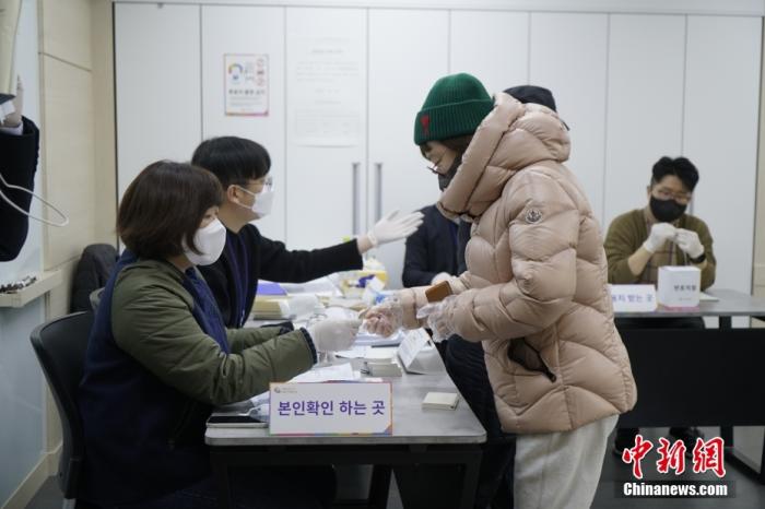 当地时间3月9日上午6时(北京时间5时)，韩国第20届总统选举投票在韩国各地超1.44万个投票点同时展开。图为首尔市钟路区一投票站内，工作人员核对选民身份。 中新社记者 刘旭 摄