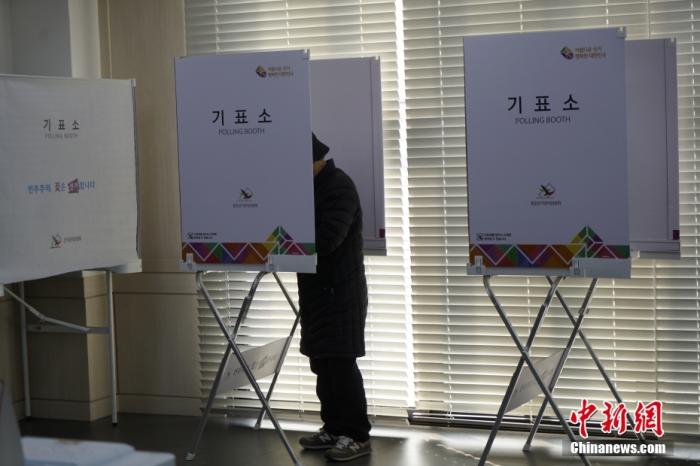图为首尔市钟路区一投票站内，选民在写票间内写选票。中新社记者 刘旭 摄