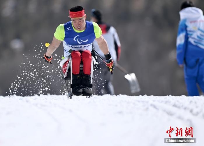 3月12日，北京2022年冬残奥会残奥越野滑雪男子中距离-坐姿决赛在张家口国家冬季两项中心举行，中国选手毛忠武以29分10秒7的成绩夺得冠军。图为毛忠武在比赛中奋力滑行。 中新社记者 侯宇 摄