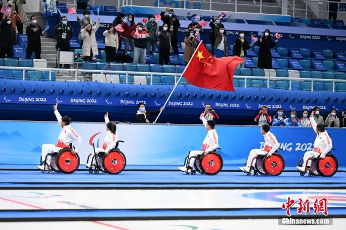 3月12日，中国队选手孙玉龙、闫卓、张明亮、陈建新和王海涛向观众致意。当日，在北京国家游泳中心“冰立方”举行的北京2022年冬残奥会轮椅冰壶金牌赛中，中国队以8比3战胜瑞典队，夺得冠军。 中新社记者 刘冉阳 摄