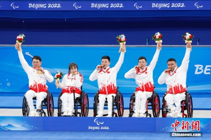 3月12日，中国队选手孙玉龙、闫卓、张明亮、陈建新和王海涛(从左至右)在颁奖仪式上。当日，在北京国家游泳中心“冰立方”举行的北京2022年冬残奥会轮椅冰壶金牌赛中，中国队以8比3战胜瑞典队，夺得冠军。 中新社记者 韩海丹 摄