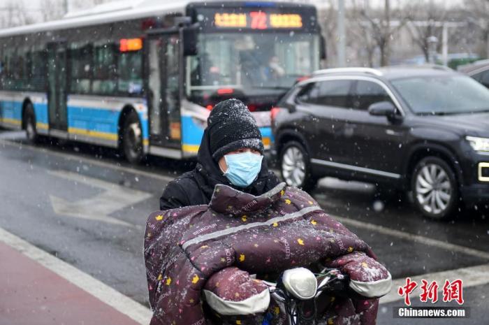 3月17日，北京市民冒雪出行。当日，北京迎降雪天气。 中新社记者 田雨昊 摄