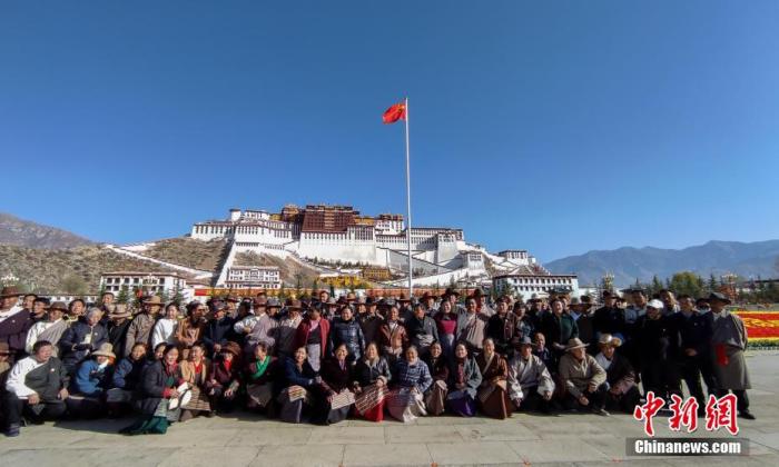 3月28日，西藏各族各界民众聚集在拉萨布达拉宫广场，升国旗、唱国歌，庆祝西藏百万农奴解放纪念日。图为民众在纪念活动后合影留念。 中新社记者 江飞波 摄
