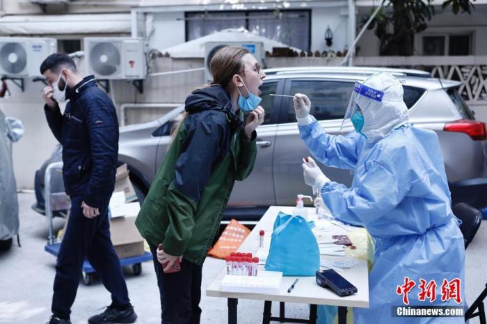4月6日，医护人员正在昭化东路199弄内为外籍人士进行核酸检测采样。 中新社记者 殷立勤 摄