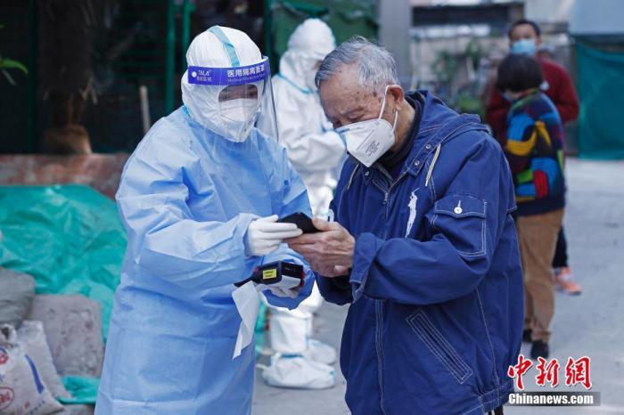 4月6日，曹家堰居委会工作人员正在昭化东路199弄内，为居民进行核酸检测采样前的信息登记。 中新社记者 殷立勤 摄