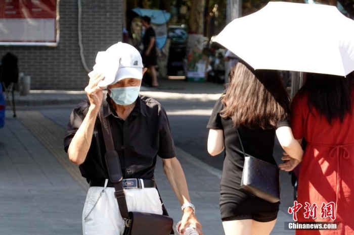 资料图：陕西西安市民遮阳出行。中新社记者 张远 摄