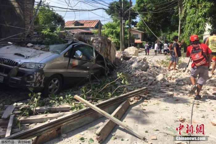 地震后墙壁倒塌，车辆被掩埋。