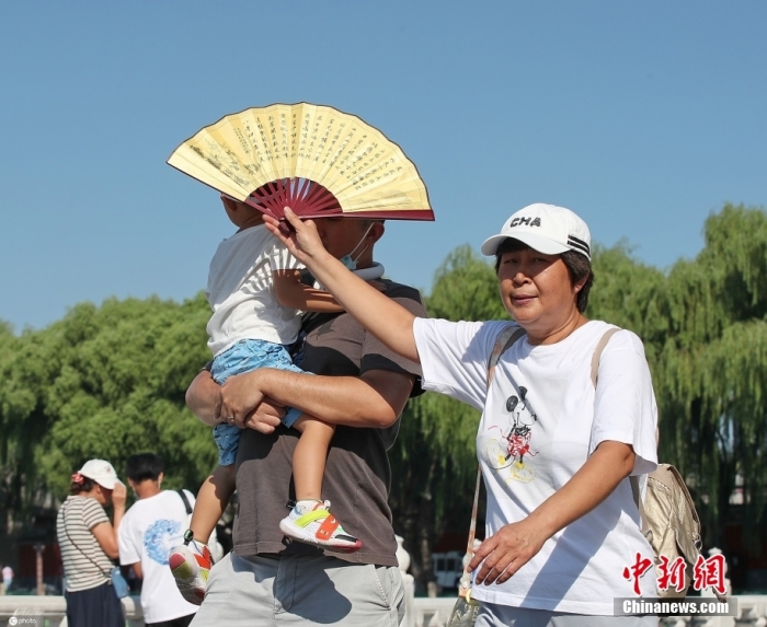 8月11日，北京，烈日下北海公园游客遮阳防晒各有妙招。当日北京晴热暴晒“加码”，紫外线照射强烈，午后最高气温攀升至32摄氏度，“热情”十足。 图片来源：ICphoto