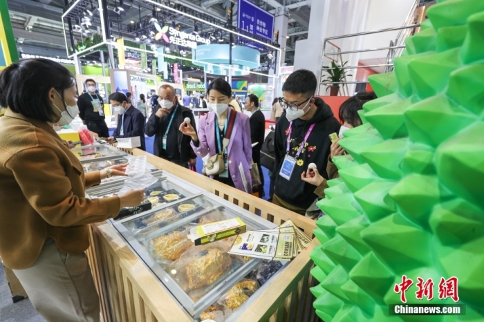 2022年11月6日，第五届中国国际进口博览会继续在国家会展中心（上海）举办。在食品及农产品展区内，观众参观马来西亚品牌“猫山王”的榴莲食品。 中新社记者 贾天勇 摄