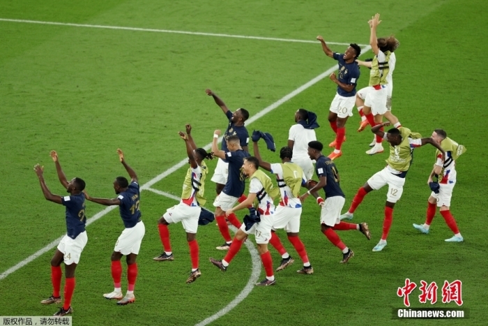 卫冕冠军法国队成为本届世界杯第一支确定从小组中出线的球队。图为法国队赛后手牵手向观众致意。