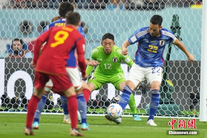北京时间12月2日，卡塔尔世界杯小组赛E组第3轮，日本队对阵西班牙队。上半场，第11分钟，莫拉塔头球破门，西班牙队1：0领先。下半场刚开始，堂安律、田中碧连进两球，日本队2：1反超西班牙队。最终，日本队2：1逆转西班牙队，小组赛两胜一负积6分，排名第一出线。西班牙队积4分小组第二晋级。图为日本队球员(蓝)解围。<a target='_blank' href='/'>中新社</a>记者 崔楠 摄