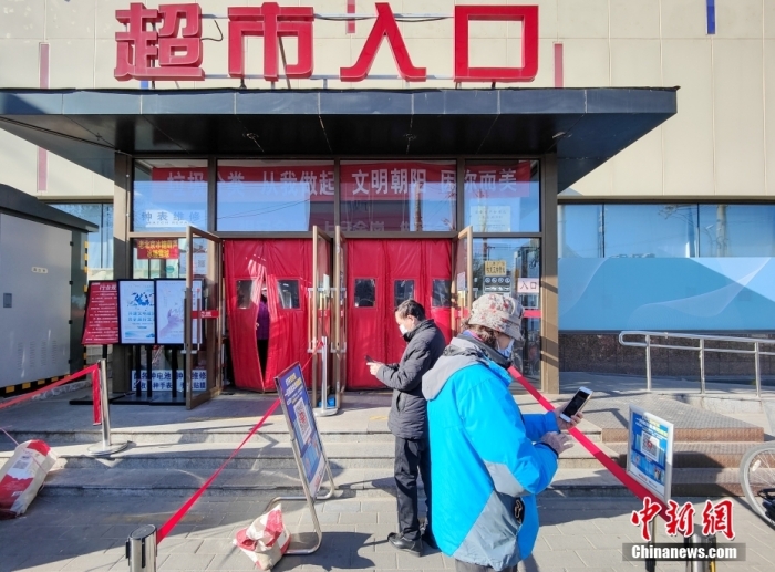 12月6日，北京，市民扫码进入一家超市购物。当日起，北京市民进入商超、商务楼宇及各类公共场所，可不查验核酸检测阴性证明，扫码进入即可。 <a target='_blank' href='/'>中新社</a>记者 贾天勇 摄