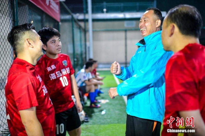 12月12日晚，海南海龙足球队教练梁其道(右二)在训练前边喊边打着手语和队员交流。 骆云飞 摄